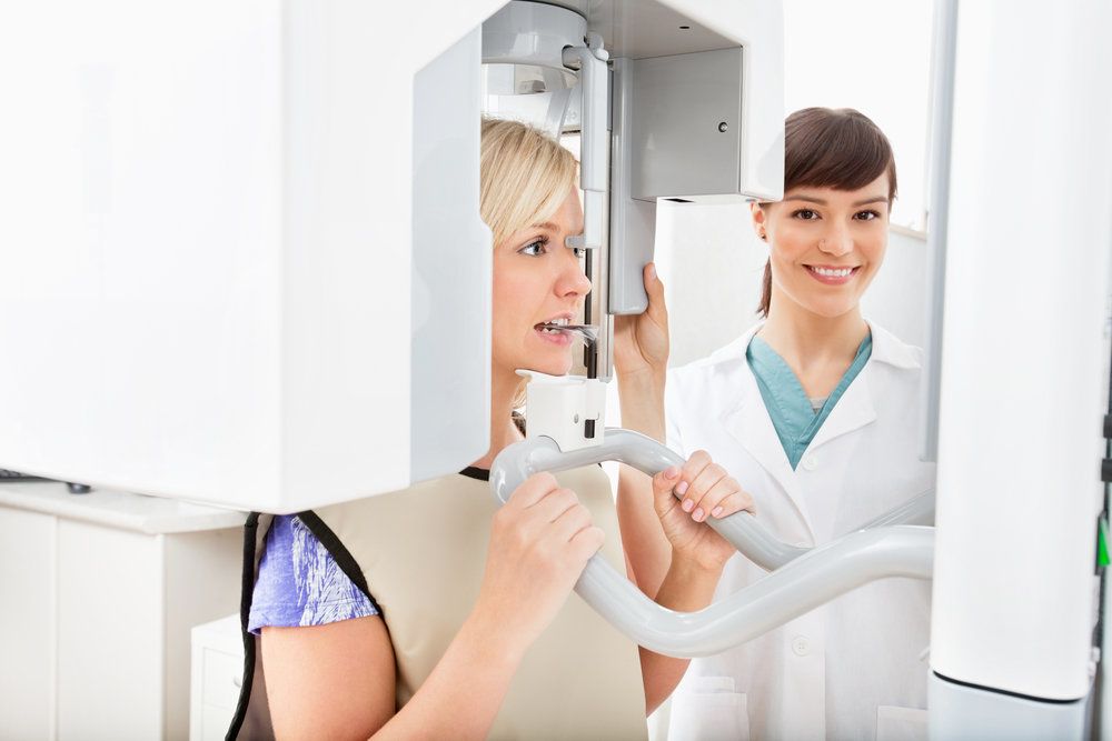 Female patient undergoing a panoramic dental x-ray