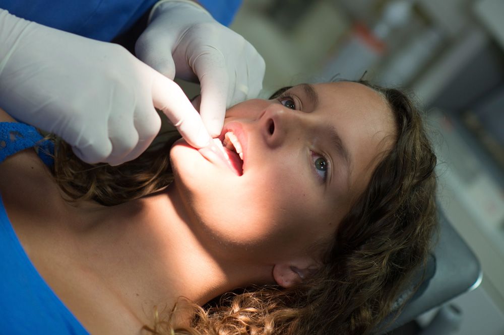 Photo of a woman undergoing an oral examination.